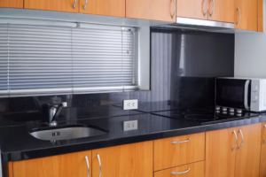 Wood kitchen cabinets with a dark counter and backsplash