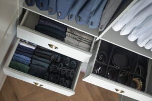 Open closet drawers organizing folded clothing and accessories