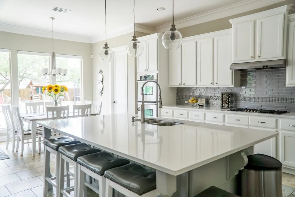 White kitchen cabinets around a large island with seating