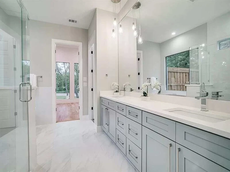 Bathroom with gray vanity cabinets and a long countertop