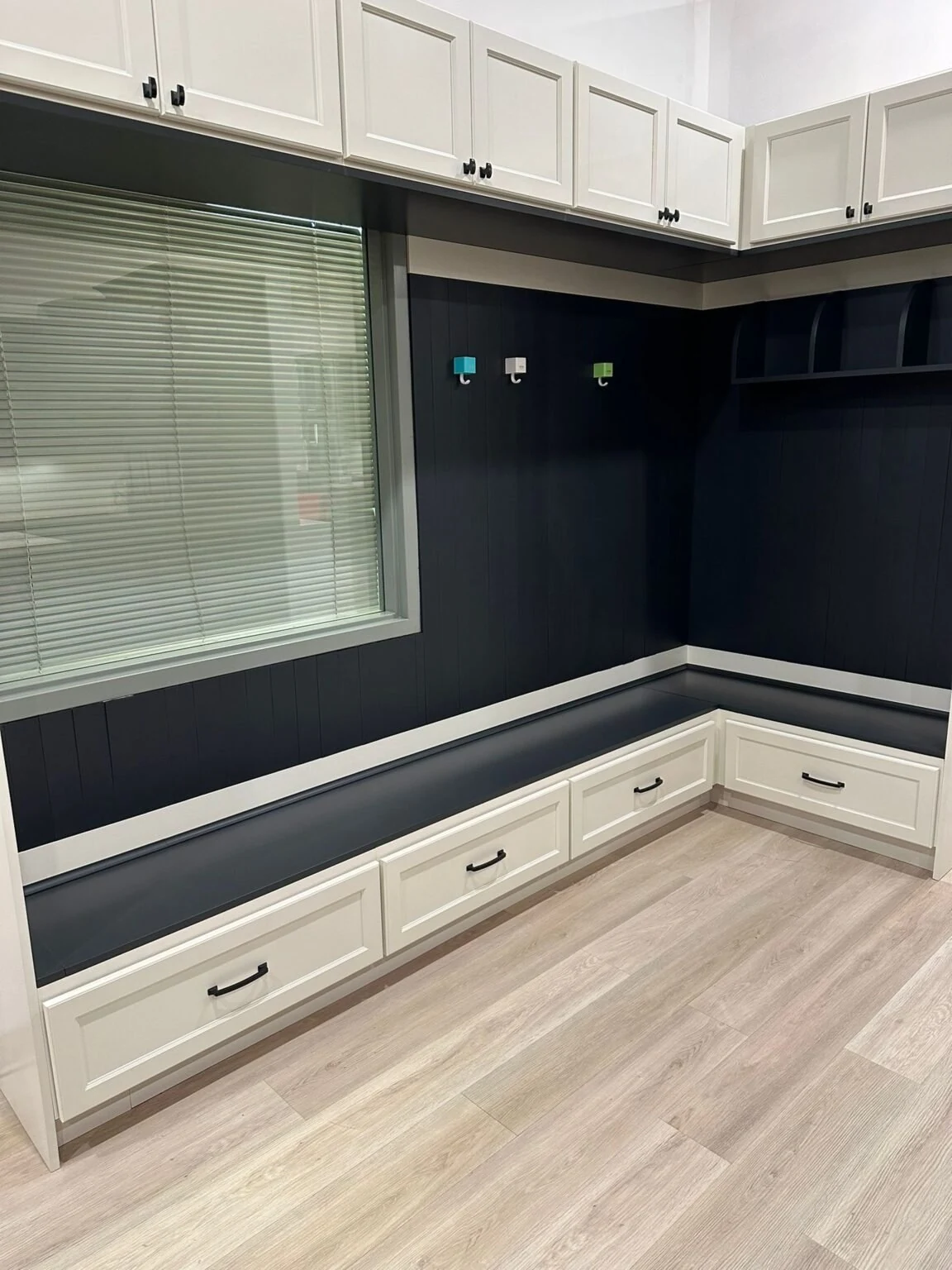 L-shaped kitchen with light cabinets and a dark backsplash