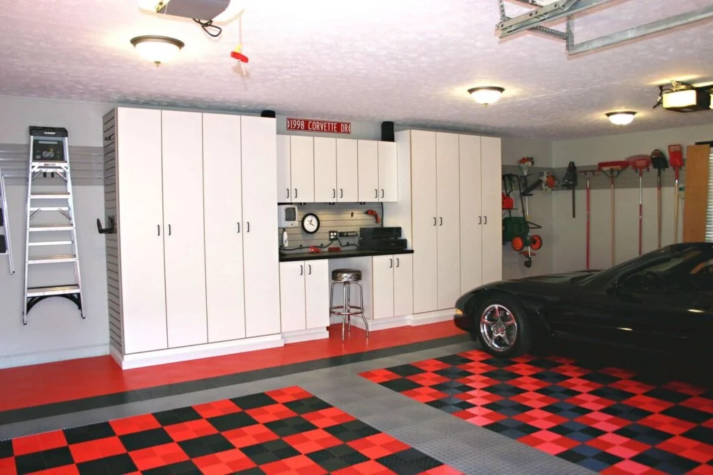 A well-designed Dallas garage featuring garage organization systems with cabinets, wall racks, and a workbench beside a parked car